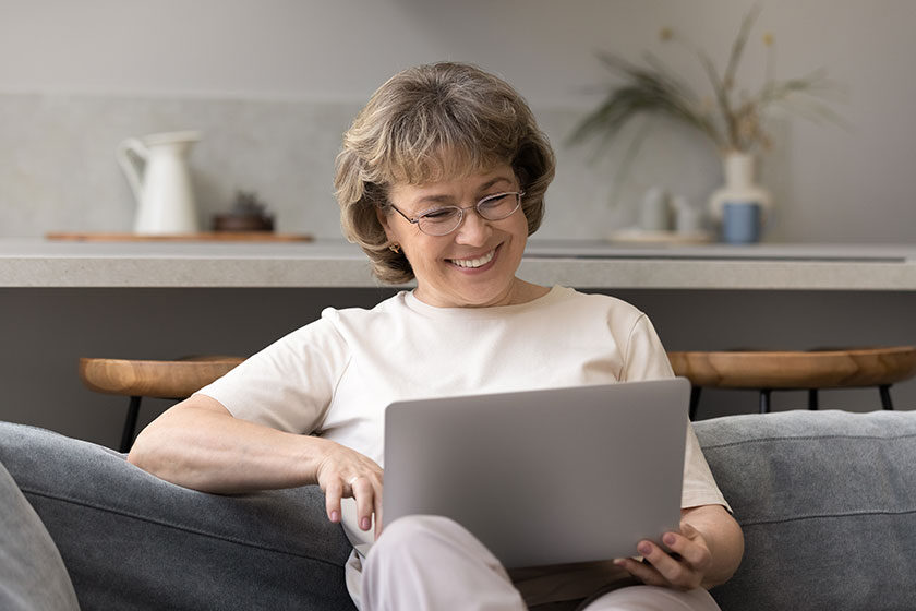 Happy mature 60s woman consulting doctor online