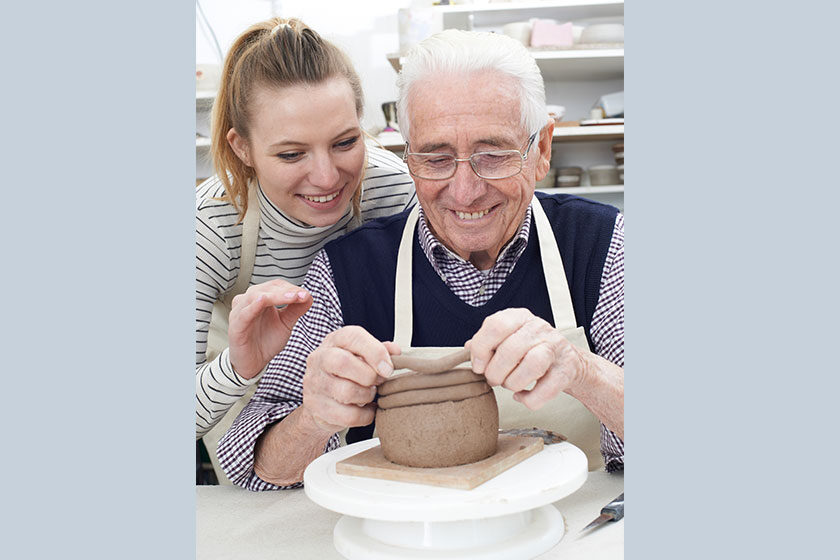 Senior Man With Teacher In Pottery Class